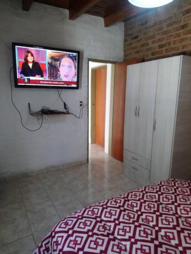 Schlafzimmer mit einem Flachbild-TV an der Wand in der Unterkunft Departamento Udine in General Roca