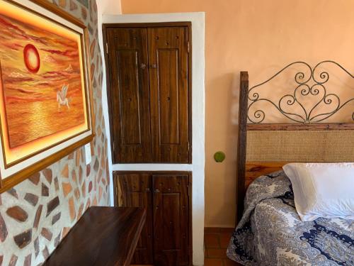 a bedroom with a bed and a wooden door at Casa Miguel Arcangel in Coatepec