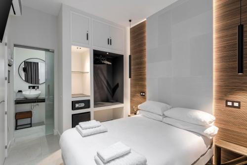 una camera bianca con un letto bianco e un lavandino di EMBA ROOM a Madrid