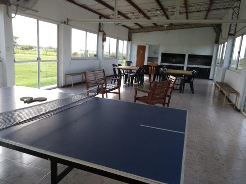 a ping pong table in a room with tables and chairs at Complejo Turístico Imagine Victoria in Victoria