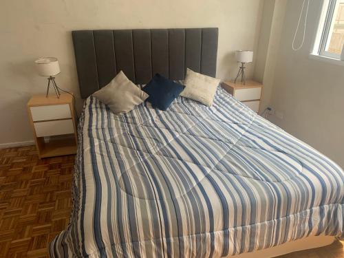 Schlafzimmer mit einem großen Bett mit blauer und weißer Bettwäsche in der Unterkunft Espectacular y moderno Departamento en la City porteña in Buenos Aires