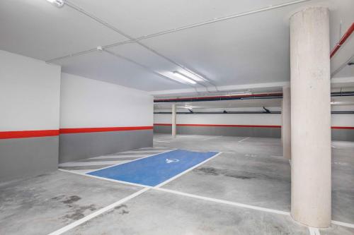 an empty parking lot with a blue floor in a garage at Hotel Ciudad De Ávila in Avila