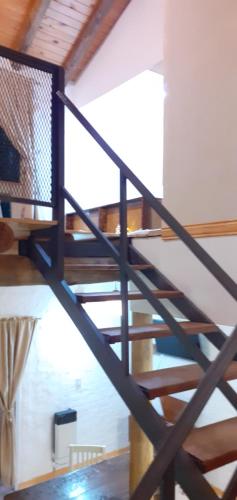 a spiral staircase in a room with wooden ceilings at Balcon de Antares in Uspallata