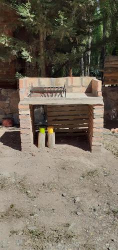 a stone bench in a park with two stools at Balcon de Antares in Uspallata