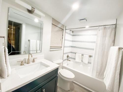 uma casa de banho branca com um lavatório e um WC em 365 Ocean em Boca Raton