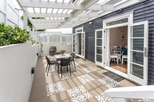 a patio with a table and chairs on it at Hampton Court in Oneroa