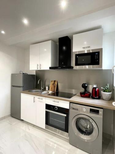 une cuisine avec un évier et une machine à laver dans l'établissement Appartement Cosy et Moderne proche de DISNEYLAND, à Bussy-Saint-Georges