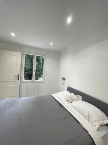 une chambre blanche avec un grand lit et une fenêtre dans l'établissement Appartement Cosy et Moderne proche de DISNEYLAND, à Bussy-Saint-Georges