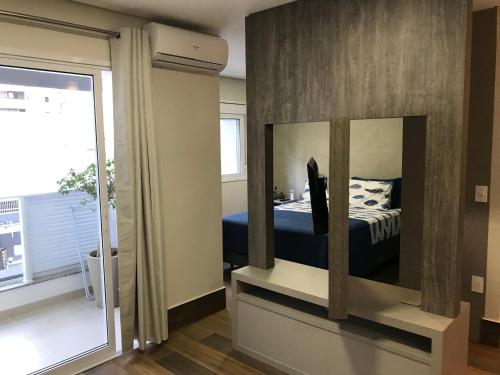 a bedroom with a bed and a large mirror at Moderno, excelente custo-benefício e localização. in Campinas