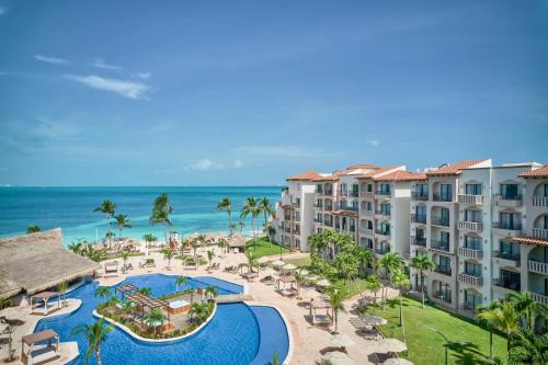 カンクンにあるFiesta Americana Cancun Villasのスイミングプールと海を望むリゾートの空中ビュー