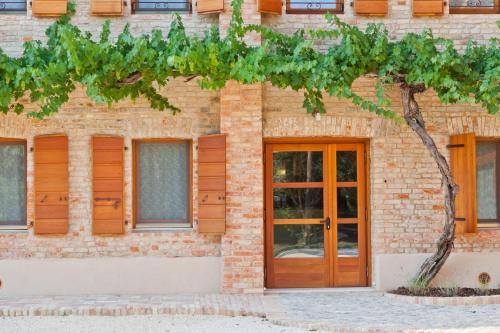 a brick building with a wooden door at Ca' Muliner in Azzano Decimo