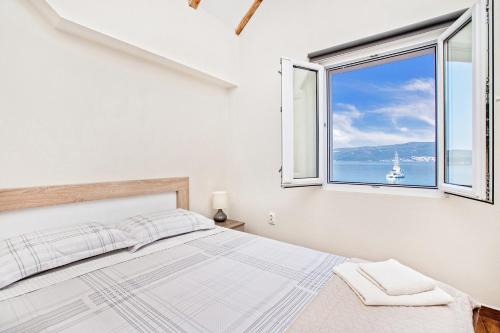 a bedroom with a bed and a large window at Apartments Isja in Tivat