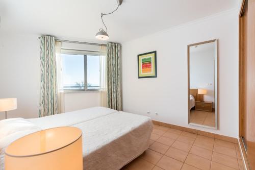 um quarto com uma cama e um espelho grande em La Francesa Algarve em Monte Gordo