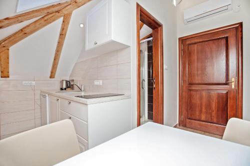 a kitchen with a table and a wooden door at Apartments Isja in Tivat