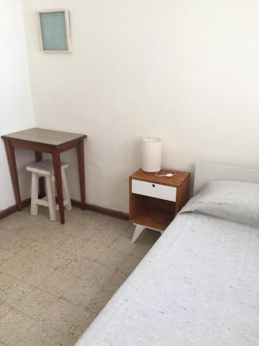 a bedroom with a bed and a night stand and a table at Casa Nanet Hotel in Mar del Plata