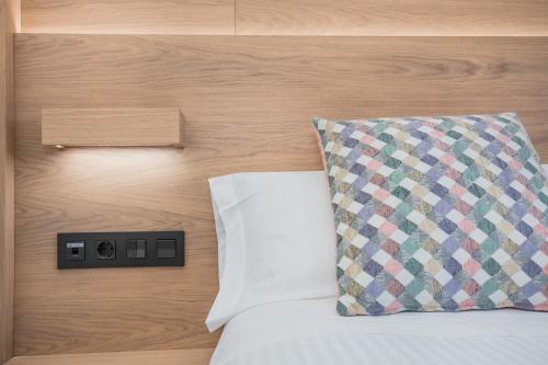 a bed with a pillow next to a wooden wall at Hotel Ciudad De Ávila in Avila