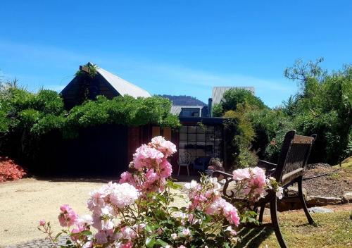 a bench and flowers in front of a building at Red Brier Cottage Accommodation in Richmond