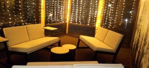 a room with two chairs and christmas lights at Зоряні Карпати in Slavske