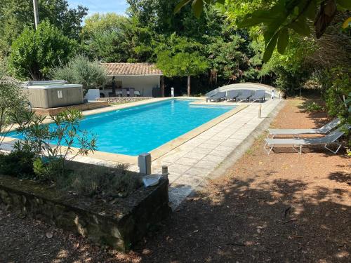 a swimming pool in a yard next to a house at GITE CLARIMOR in Puygiron