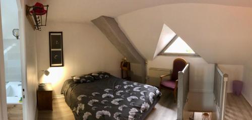een slaapkamer op zolder met een bed en een raam bij Appartement Cosy avec Balcon au calme proche Gare in Bernay