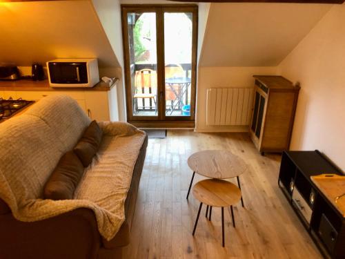 a living room with a couch and a table at Appartement Cosy 600m Gare - étage 3 - balcon et calme - TV - wifi in Bernay