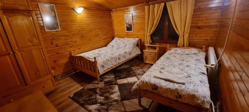 a bedroom with two beds in a wooden cabin at The Green King in Borovets