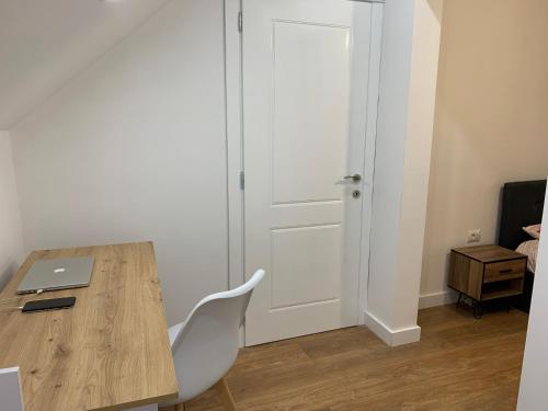 a room with a wooden table with a laptop on it at Noah's Attic - Apartment Hotel in Korce in Korçë