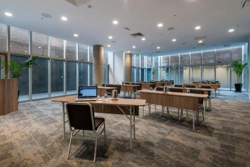 a conference room with tables and chairs and a laptop at Holiday Inn - Lima Airport by IHG in Lima