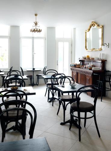 a dining room with tables and chairs and a mirror at Boutique Hotel Grote Gracht in Maastricht