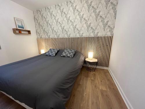 a bedroom with a bed with two pillows on it at Superbe appartement en Centre ville d'ARRAS in Arras