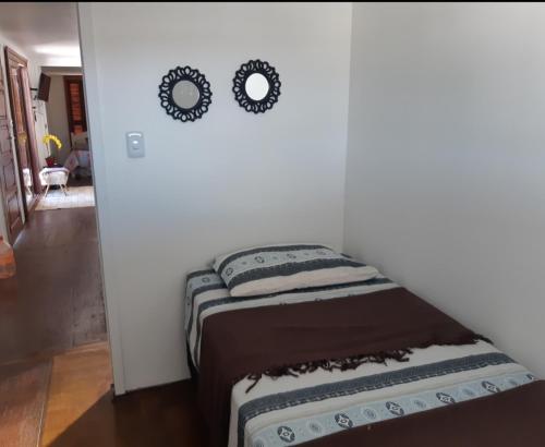 Cette chambre comprend 2 lits et 2 miroirs sur le mur. dans l'établissement Lugar encantador com bela paisagem, à Bagé