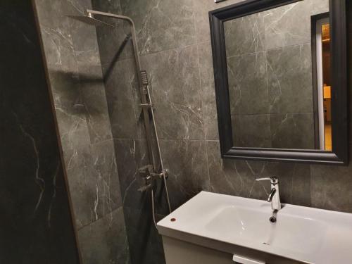 y baño con lavabo y ducha con espejo. en Private Cottage 375 en Bukovel