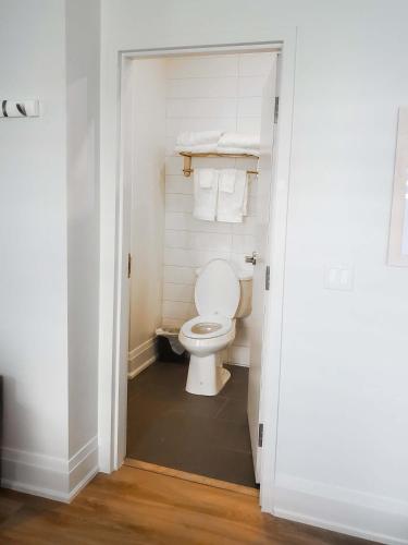 a bathroom with a white toilet in a room at Colonial Hotel & Suites in Grand Bend