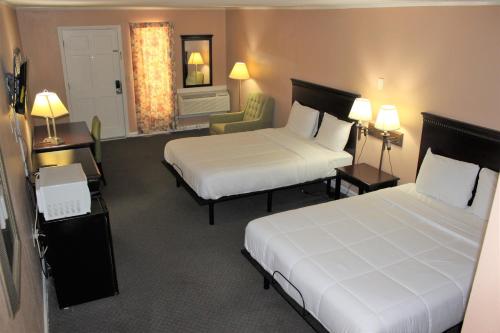 a hotel room with two beds and a chair at Bar-Mel Inn in McCormick
