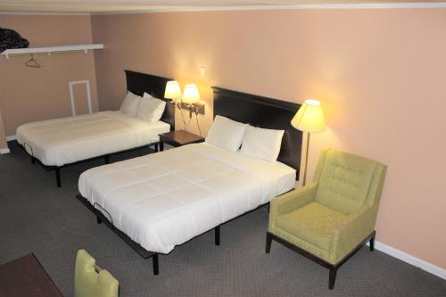 a hotel room with two beds and a chair at Bar-Mel Inn in McCormick