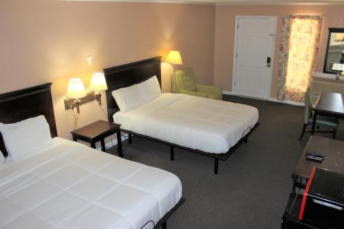 a hotel room with two beds and a chair at Bar-Mel Inn in McCormick
