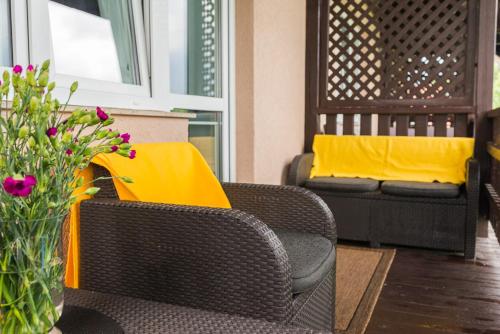 a living room with two chairs and a couch with yellow pillows at Willa Borowski in Barlinek