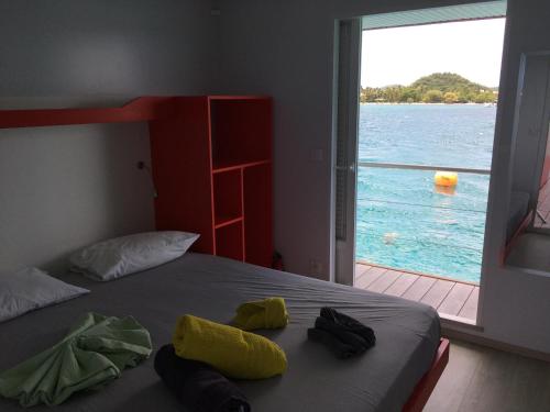 a bedroom with a bed with a view of the water at Aqualodge Martinique in Le Marin