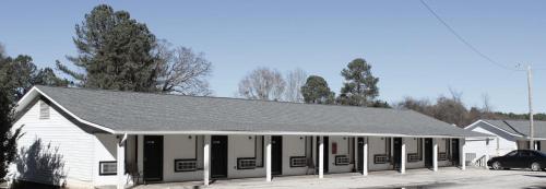 a white building with a gray roof at Bar-Mel Inn in McCormick