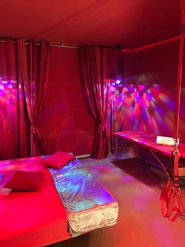 a room with a bed and a table with purple lights at La Mazmorra de Lucifer in Madrid