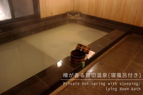 a pool of water with a trash can in it at Ajisai Onsen Ryokan - Award Winning Private Open Air Onsen in Hakone