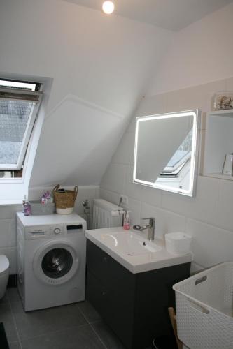 y baño con lavadora y lavamanos. en 3-Zi. Wohnung in Verden/Hönisch- 24_7 self-check-in, en Hönisch