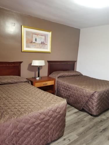 a hotel room with two beds and a lamp at Richard lake motel in Coniston