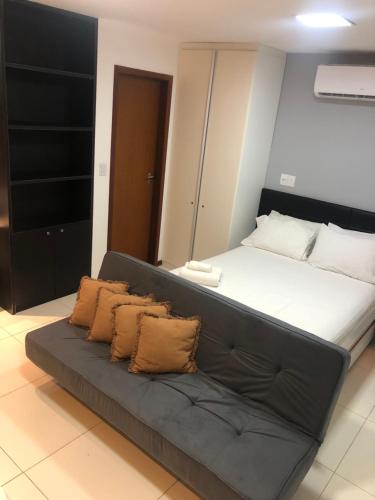uma cama grande com um sofá num quarto em Villas do Pratagy - Pitanga B3 em Maceió