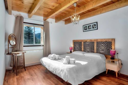 Un dormitorio con una gran cama blanca y una ventana en CASA PELAIRE - Wifi, barbacoa, pistas 4 min a pie, en Panticosa