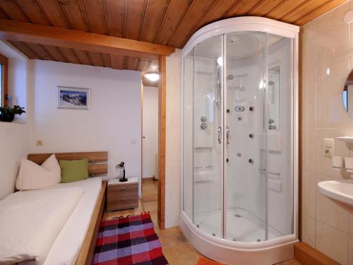 una camera da letto con doccia, letto e lavandino di Single Apartment Martlerhof a Tux