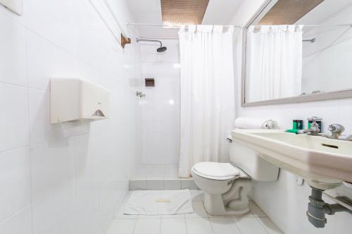 a white bathroom with a sink and a toilet at Ayenda Nuevo Escorial in Manizales