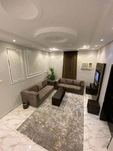 a living room with a couch and a tv at Opera Suites in Muhayil