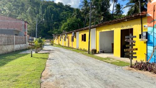 una calle vacía con un edificio amarillo al lado de una carretera en Chalés Paraíso dos Milagres en São Miguel dos Milagres