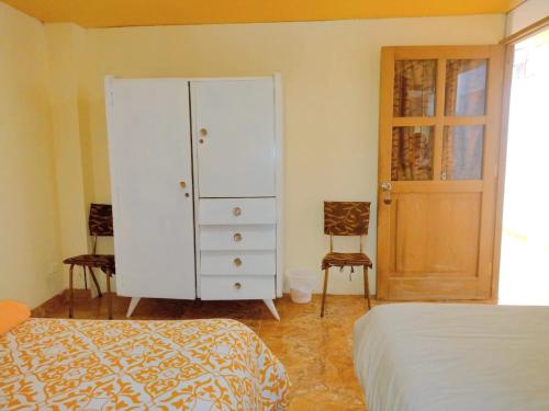 um quarto com um armário branco e uma cama em BiosWild em Cusco